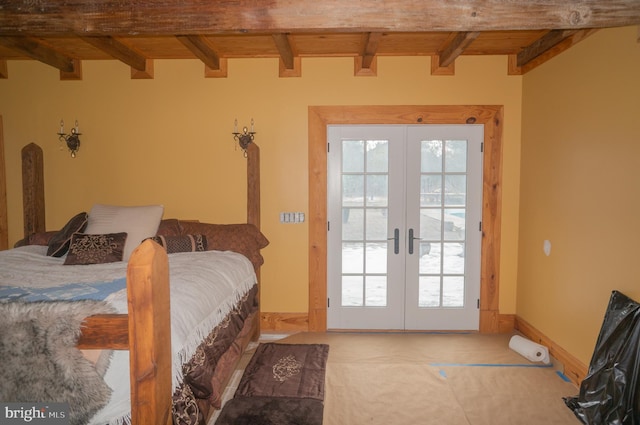 bedroom featuring beam ceiling, multiple windows, and french doors