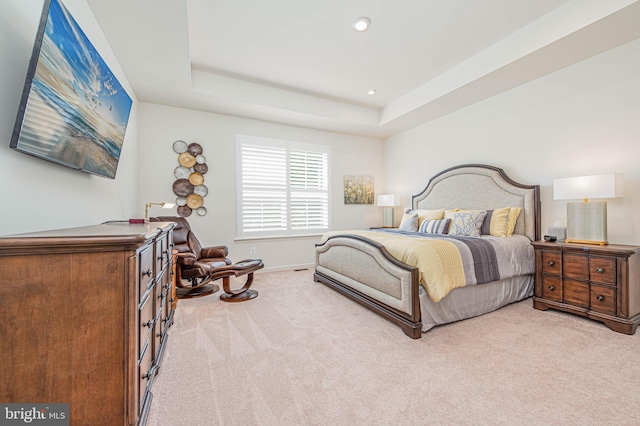 carpeted bedroom with a tray ceiling