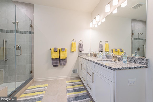 bathroom featuring oversized vanity, double sink, walk in shower, and tile flooring