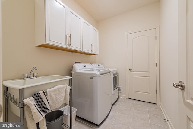 clothes washing area featuring light tile floors, cabinets, washer hookup, and independent washer and dryer