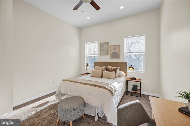 bedroom featuring multiple windows, dark colored carpet, and ceiling fan