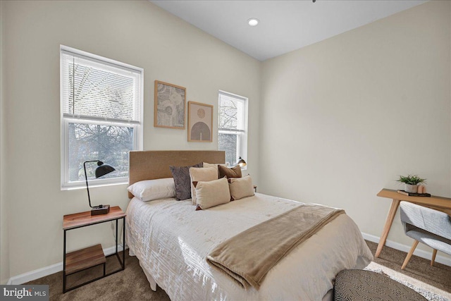 bedroom with dark colored carpet and multiple windows