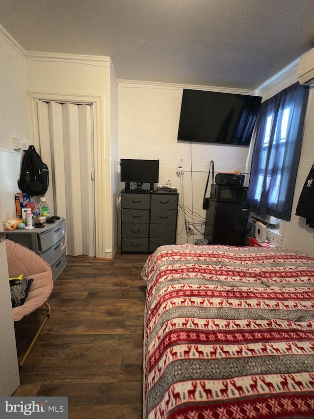 bedroom featuring crown molding, dark hardwood / wood-style flooring, a wall unit AC, and a textured ceiling