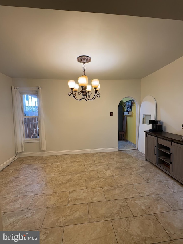 unfurnished room featuring an inviting chandelier