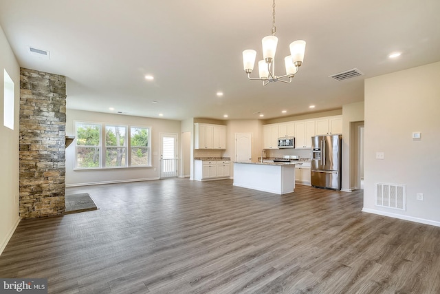 kitchen featuring pendant lighting, dark hardwood / wood-style flooring, white cabinets, appliances with stainless steel finishes, and an inviting chandelier