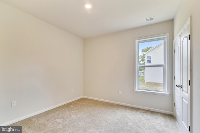 empty room with light colored carpet and a wealth of natural light