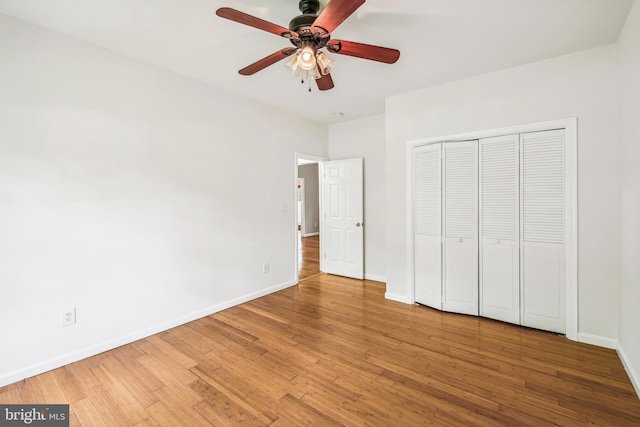 unfurnished bedroom with hardwood / wood-style flooring, ceiling fan, and a closet