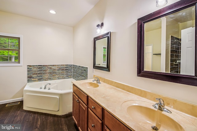 bathroom featuring a washtub, vanity, and wood-type flooring