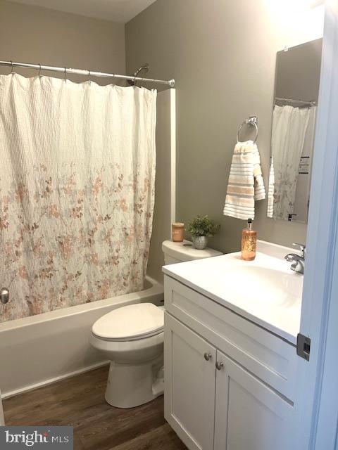 19 Pacific Ave, Milroy, PA 17063 - full bathroom with vanity, toilet, hardwood / wood-style floors, and shower / bath combo with shower curtain