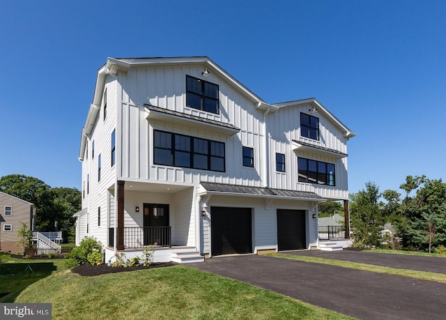 modern farmhouse style home with a front yard and a garage