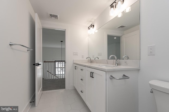 bathroom featuring double vanity, toilet, and tile floors