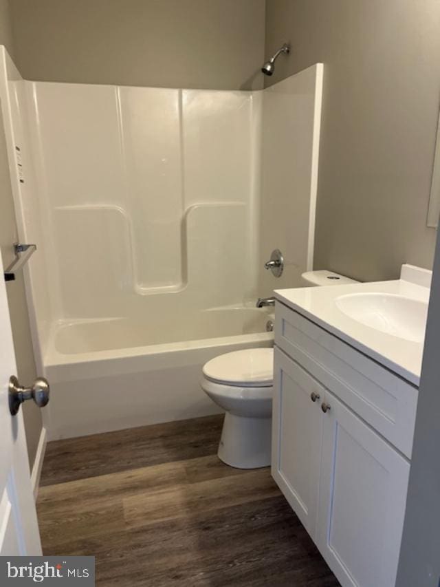 bathroom featuring toilet, bathtub / shower combination, wood finished floors, and vanity