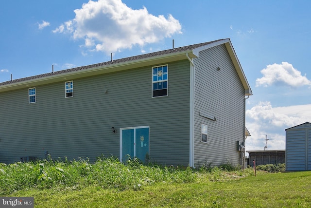 rear view of property featuring a lawn