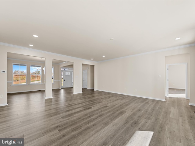 unfurnished living room featuring crown molding and hardwood / wood-style floors