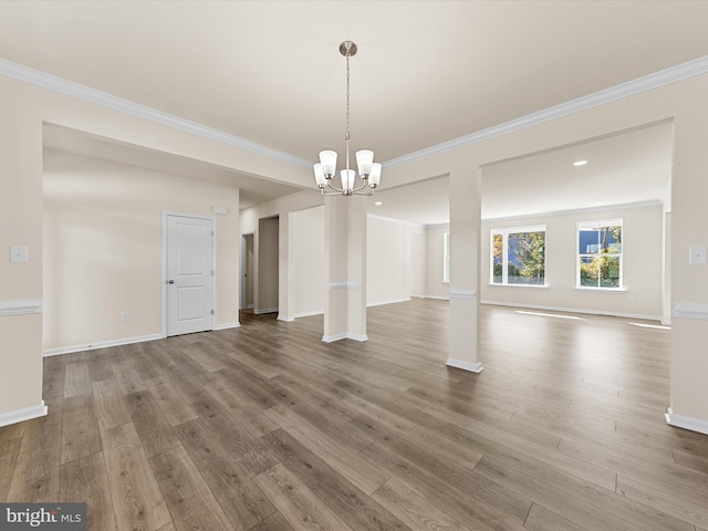 unfurnished dining area featuring a chandelier, hardwood / wood-style floors, and crown molding