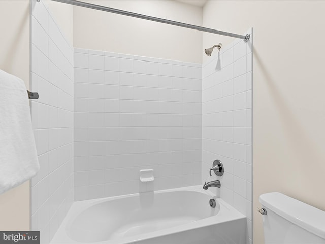 bathroom with toilet and tiled shower / bath