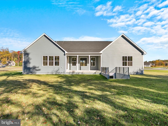 back of property featuring a lawn and covered porch