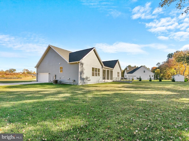 view of property exterior featuring central air condition unit, a garage, and a lawn