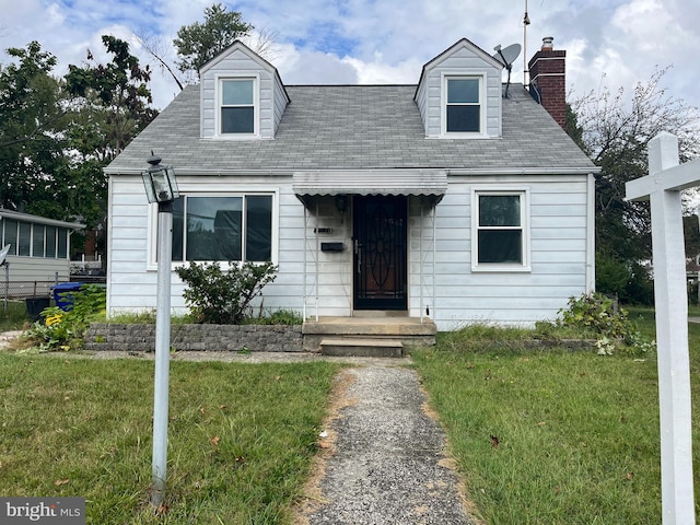 cape cod home with a front yard