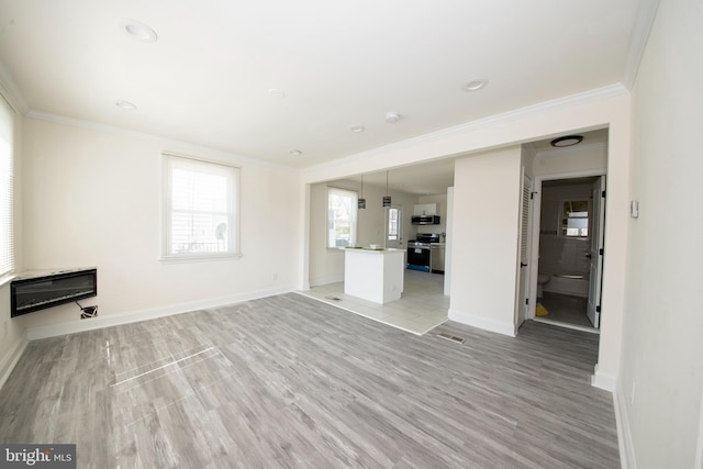 unfurnished living room featuring ornamental molding, light wood-type flooring, and heating unit