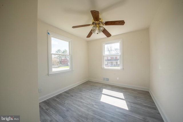 empty room with ceiling fan and dark wood-type flooring