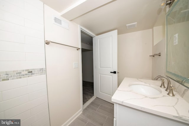 bathroom with vanity and tile walls