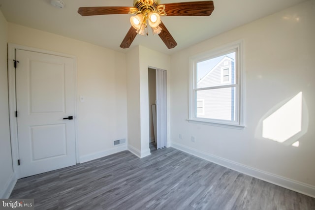 unfurnished bedroom featuring dark wood-type flooring and ceiling fan