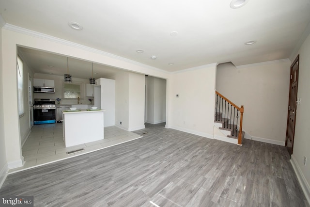 unfurnished living room with ornamental molding and light hardwood / wood-style floors