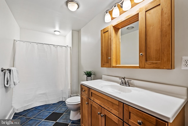 bathroom with tile floors, toilet, and vanity