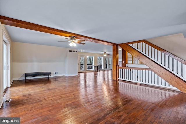 unfurnished living room with ceiling fan, hardwood / wood-style floors, and beam ceiling