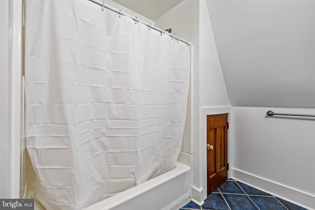 bathroom with shower / bathtub combination with curtain, tile flooring, and lofted ceiling