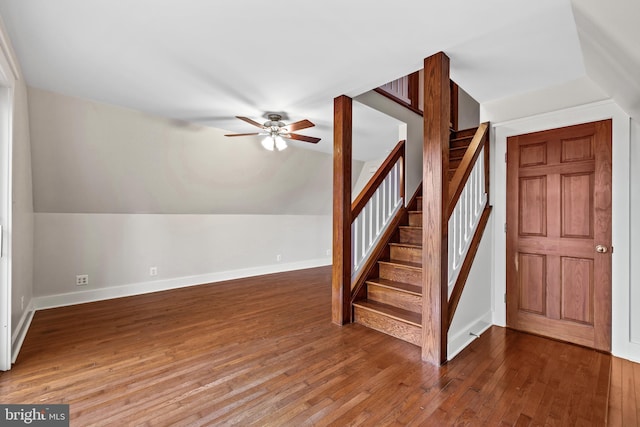 staircase featuring wood-type flooring, ceiling fan, and vaulted ceiling