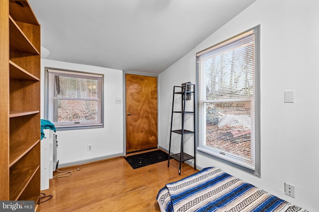 bedroom featuring vaulted ceiling and light wood-type flooring