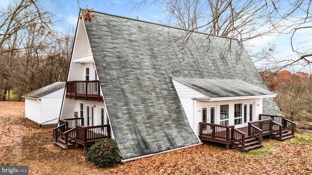 rear view of property featuring french doors and a wooden deck