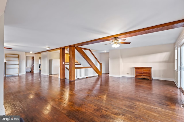 unfurnished living room featuring ceiling fan and dark wood-type flooring