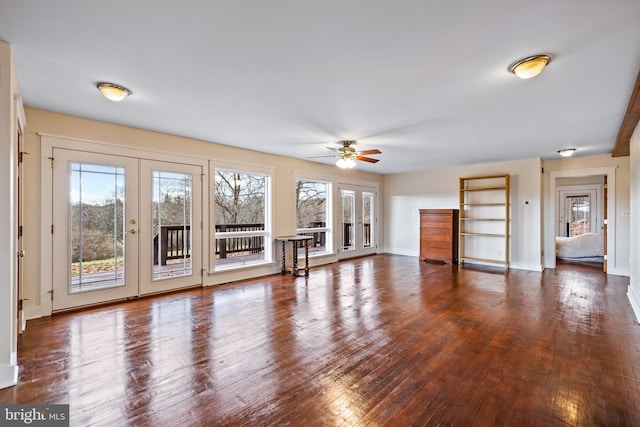 unfurnished living room featuring a healthy amount of sunlight, dark hardwood / wood-style floors, and ceiling fan