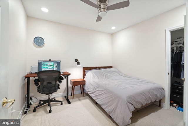 bedroom featuring ceiling fan, a spacious closet, light colored carpet, and a closet