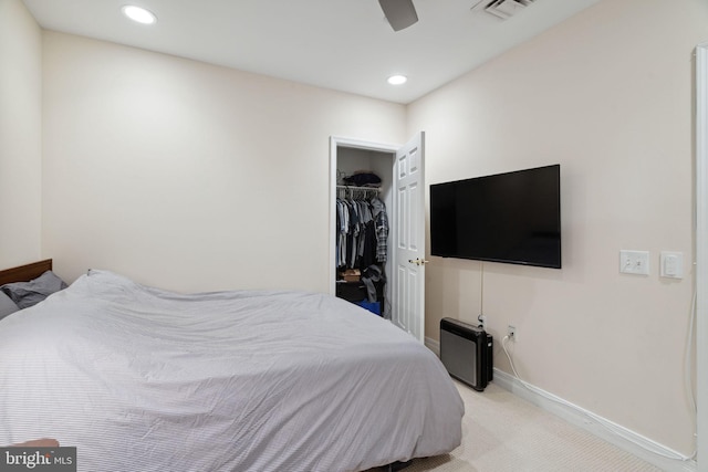 bedroom with light carpet, a spacious closet, a closet, and ceiling fan