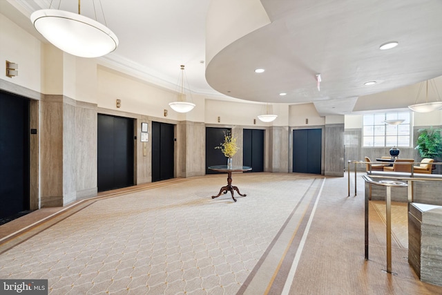 interior space featuring light carpet, elevator, and a towering ceiling