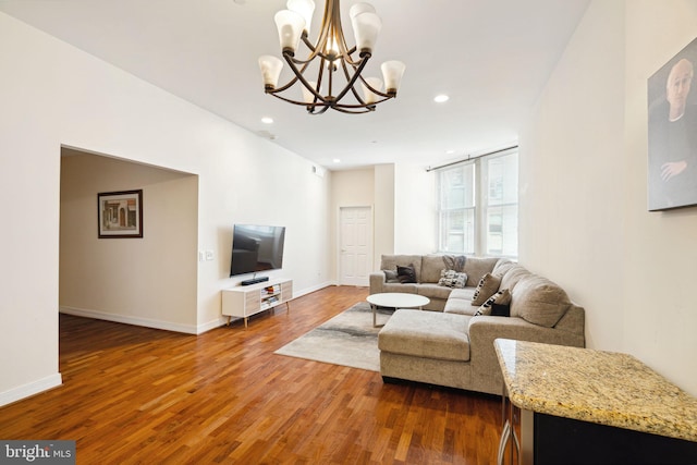 living room with a notable chandelier and dark wood-type flooring