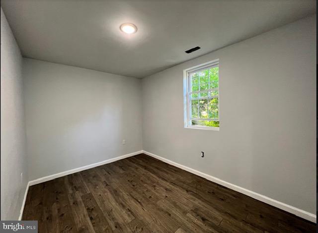 empty room with dark wood-type flooring