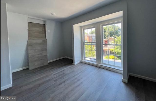 unfurnished room featuring dark hardwood / wood-style flooring