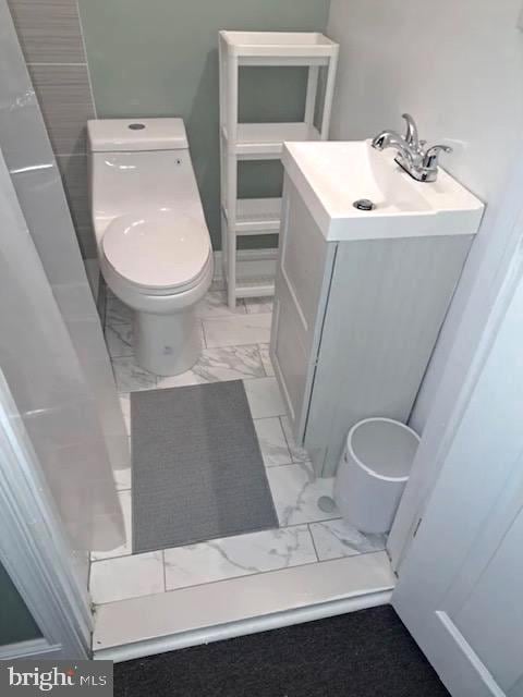 bathroom featuring toilet, tile flooring, and vanity