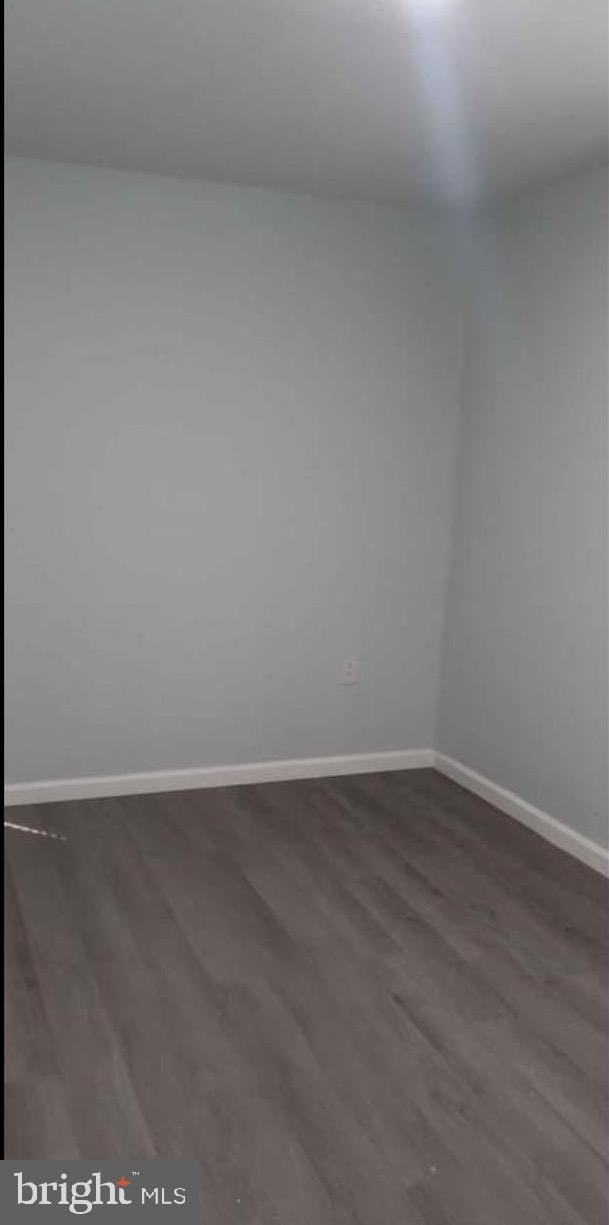 empty room with dark hardwood / wood-style flooring