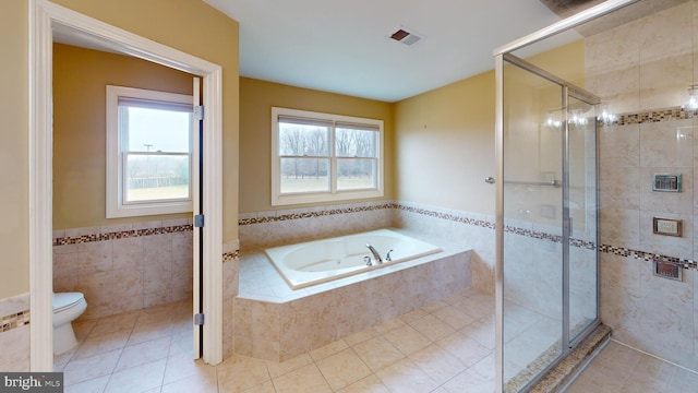 bathroom featuring tile floors, toilet, and a healthy amount of sunlight