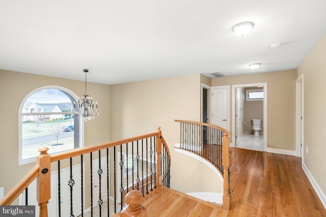 hall with an inviting chandelier and hardwood / wood-style floors