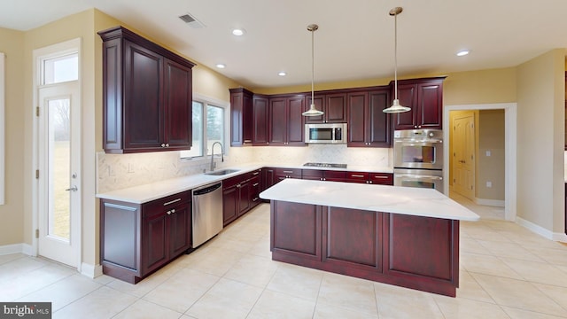 kitchen featuring backsplash, decorative light fixtures, a healthy amount of sunlight, and appliances with stainless steel finishes