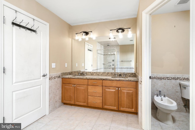 bathroom with tile walls, dual bowl vanity, a bidet, and tile flooring