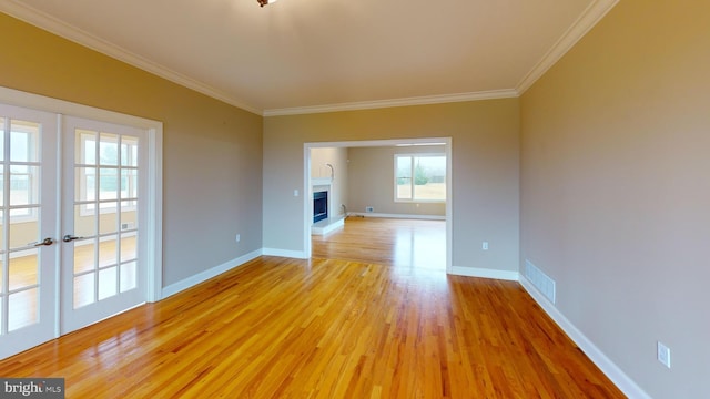 spare room featuring light hardwood / wood-style floors, french doors, and crown molding