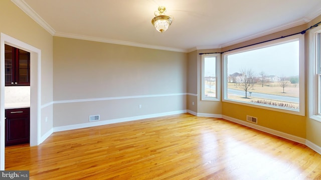 unfurnished room featuring ornamental molding and light wood-type flooring